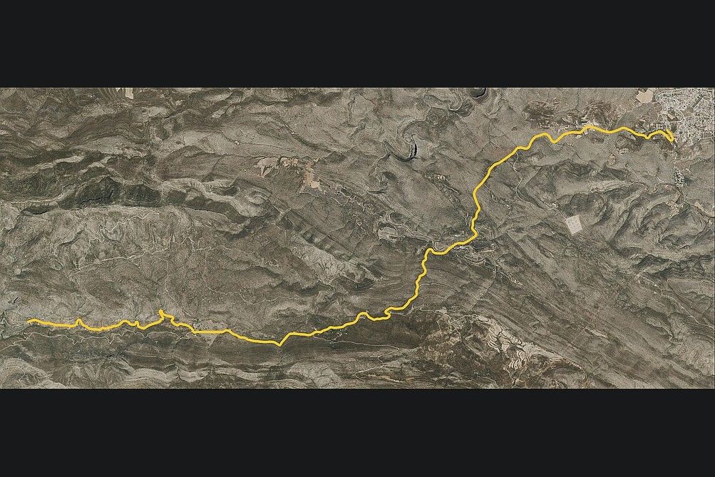 Aerial photo with the Dos Aguas stage route in yellow, crossing the bare hills to the village.