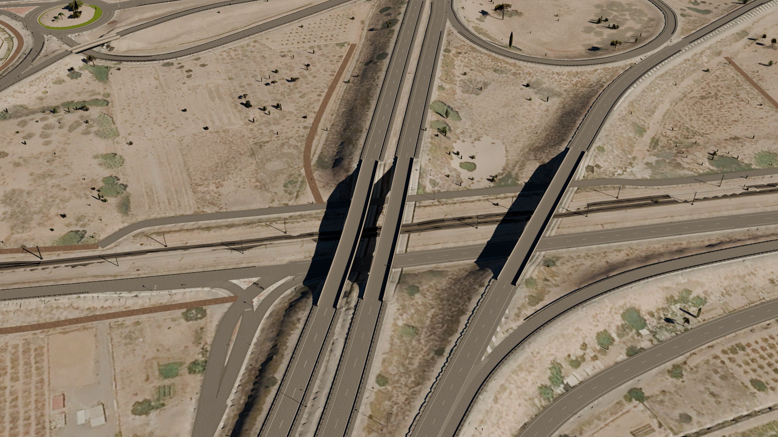 Vista aérea oblicua de un enlace de autopista: los puentes sobre la vía del tren, los ramales y las rotondas.