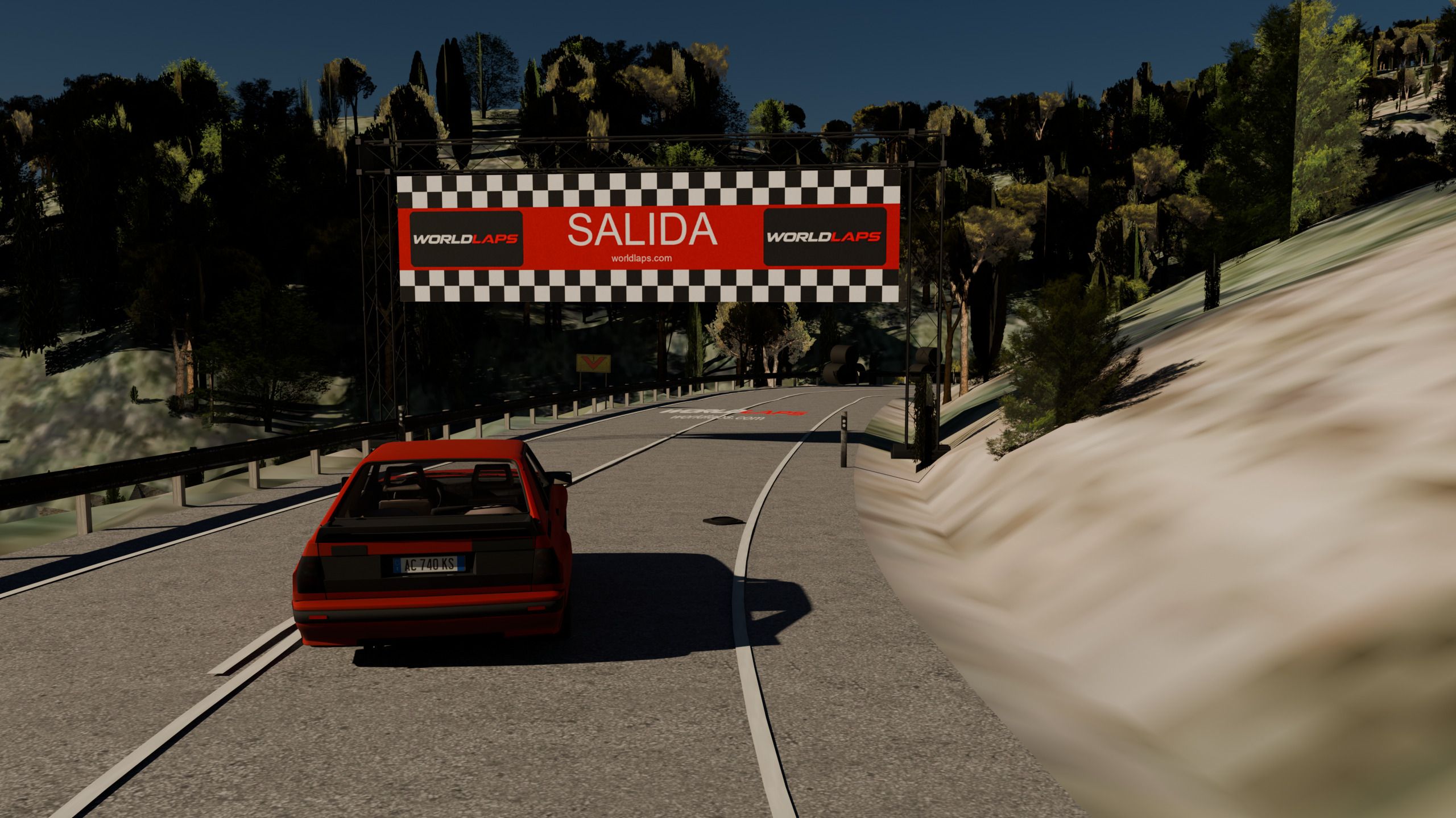La pista cargada en Assetto Corsa: el coche parado en la salida, bajo el pórtico de SALIDA, con la carretera entrando en la curva.
