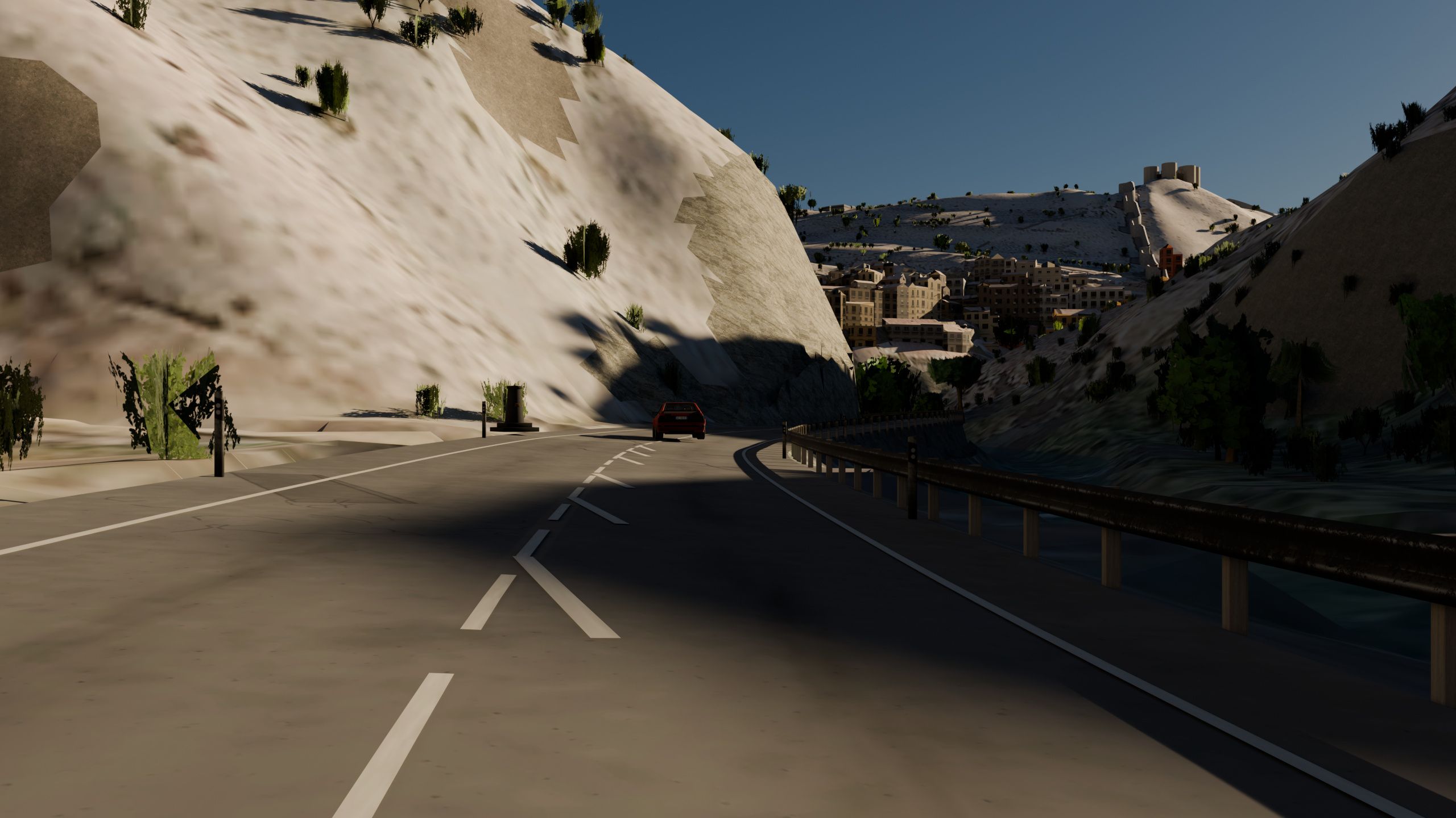 Carretera A-1512 a la entrada de Albarracín generada por Worldlaps, a nivel de parachoques: la línea discontinua que se vuelve continua antes de la curva, el quitamiedos sobre la hoz del río, un coche rojo saliendo de la curva y el pueblo con su muralla y el castillo al fondo.