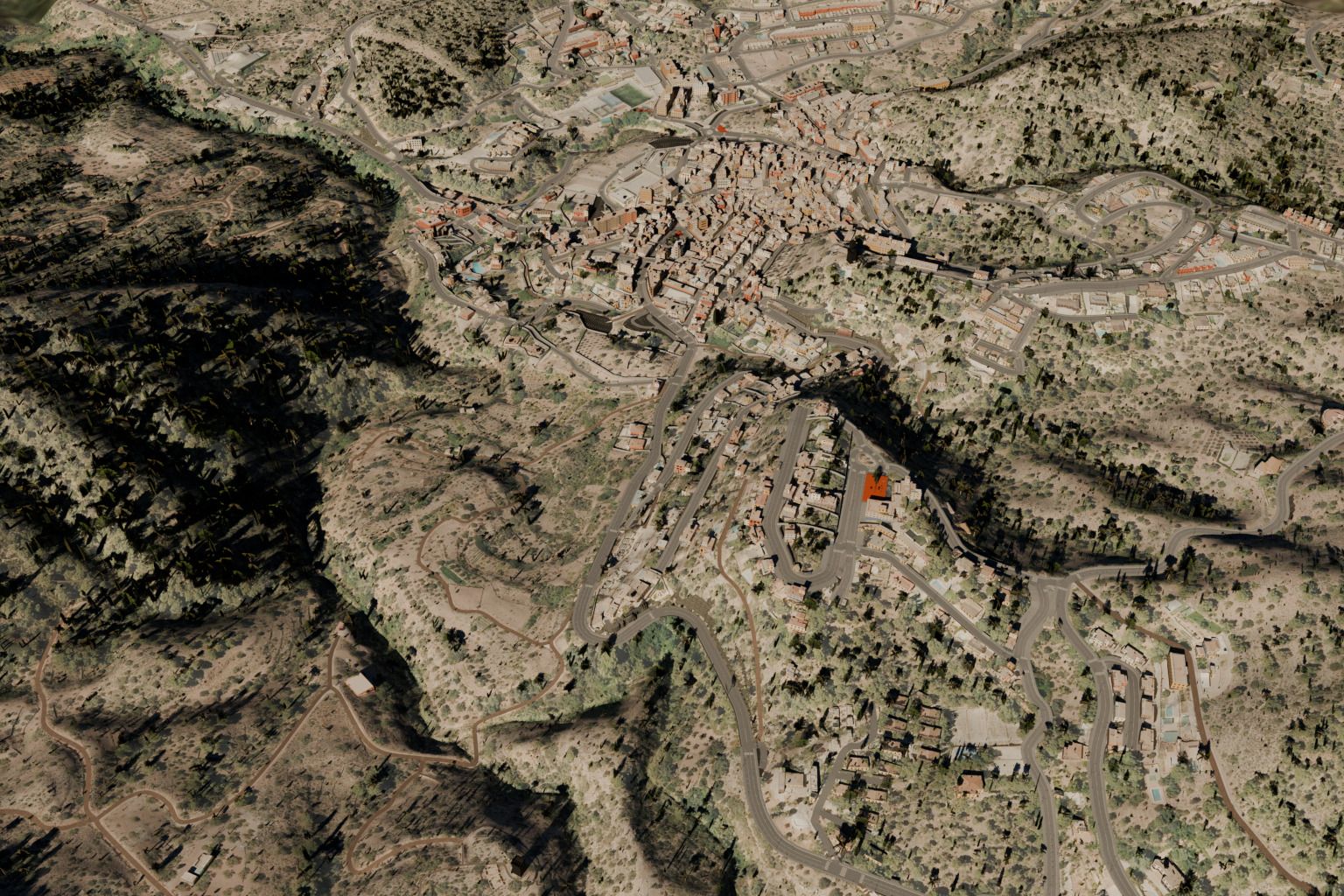 Vista aérea del tramo de la CV-310 en Serra: la carretera serpentea por la ladera entre pinos y el pueblo queda arriba.